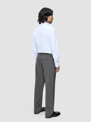 A man seen from behind wearing a white button-down shirt and Ease Pants Relaxed Fit Dark Grey.