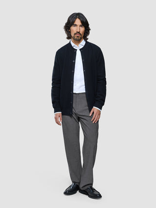 A man wearing a dark button-up cardigan over a white dress shirt and Ease Pants Relaxed Fit Dark Grey.