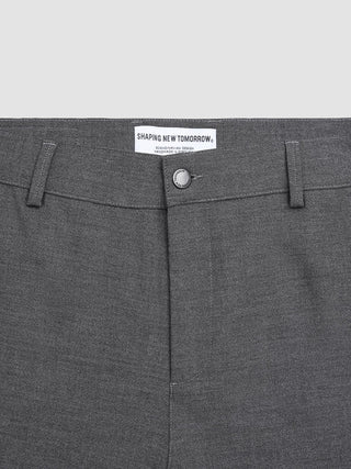 Close-up of Ease Pants Relaxed Fit Dark Grey with a waistband label reading Shaping New Tomorrow, Handmade in Portugal.