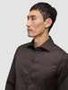 A person wearing an Elevated Shirt Regular Dark Brown, a long-sleeved Pima cotton button-down shirt.