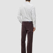 A man seen from behind wearing an Elevated Shirt Regular Light Grey Striped button-down shirt tucked into dark brown trousers and dark leather shoes.