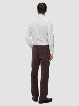 A man seen from behind wearing an Elevated Shirt Regular Light Grey Striped button-down shirt tucked into dark brown trousers and dark leather shoes.