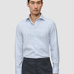 A man wearing an Elevated Shirt Slim Classic Blue Striped long-sleeve dress shirt tucked into dark grey trousers.