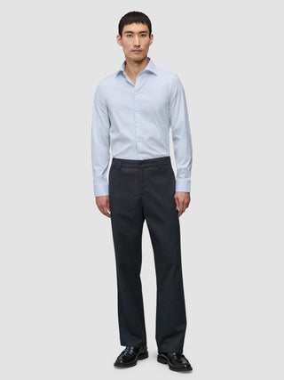 A man wearing an Elevated Shirt Slim Classic Blue Striped light blue button-up shirt with dark trousers and black loafers.