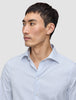 A man wearing an Elevated Shirt Slim Classic Blue Striped, a slim fit, light blue and white vertically striped Pima cotton button-down shirt.
