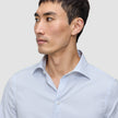 A man wearing an Elevated Shirt Slim Classic Blue Striped, a slim fit, light blue and white vertically striped Pima cotton button-down shirt.
