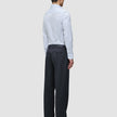 A man seen from behind wearing an Elevated Shirt Slim Classic Blue Striped light blue pinstripe long-sleeve shirt tucked into dark grey trousers and black loafers.