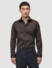 A man wearing a slim-fit dark brown Elevated Shirt Slim Dark Brown tucked into charcoal trousers.