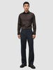 A man wearing a slim fit, dark brown Elevated Shirt Slim Dark Brown tucked into charcoal grey trousers and dark leather loafers.