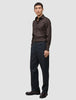 A man wearing an Elevated Shirt Slim Dark Brown, charcoal trousers, and dark brown loafers.