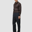 A man wearing an Elevated Shirt Slim Dark Brown, charcoal trousers, and dark brown loafers.