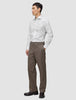 A man wearing an Elevated Shirt White Slim tucked into brown trousers and dark loafers.