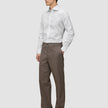 A man wearing an Elevated Shirt White Slim tucked into brown trousers and dark loafers.
