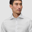 A man wearing an Elevated Shirt White Slim Pima cotton dress shirt with a spread collar and slim fit.