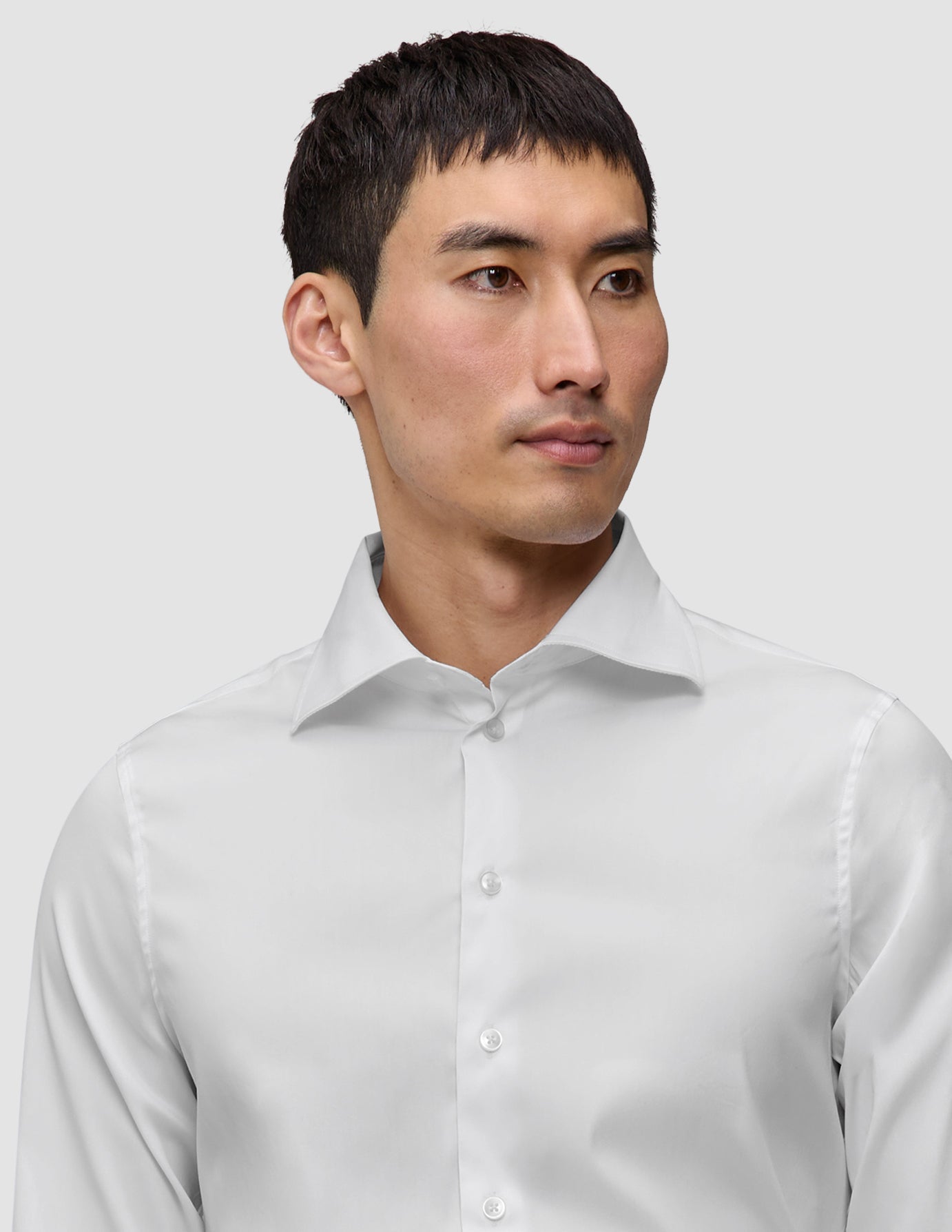 A man wearing an Elevated Shirt White Slim Pima cotton dress shirt with a spread collar and slim fit.