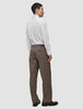 A man seen from behind wearing an Elevated Shirt White Slim tucked into brown trousers and dark loafers.