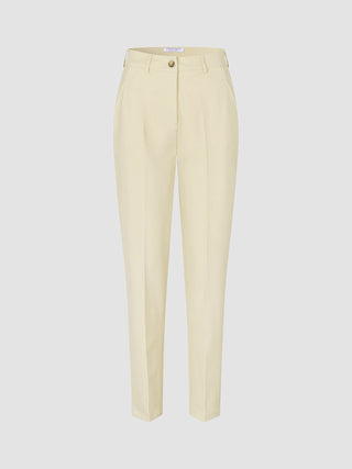 Women Essential Pants Tapered Misty Yellow featuring front pleats, a button closure, and a high-waisted Scandinavian design.
