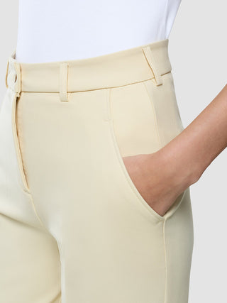 Close-up of a hand in the pocket of Women Essential Pants Tapered Misty Yellow.