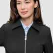 A minimalist black Essential Short Zip Jacket worn over a light blue button-down shirt.