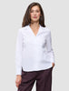 A woman wearing a white Madison Shirt with a notched collar and dark pinstriped trousers.