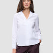 A woman wearing a white Madison Shirt with a notched collar and dark pinstriped trousers.