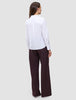 A woman seen from behind wearing a white 100% cotton Madison Shirt White and dark pinstriped wide-leg trousers.