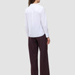 A woman seen from behind wearing a white 100% cotton Madison Shirt White and dark pinstriped wide-leg trousers.
