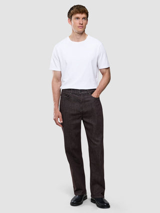 A man wearing a white t-shirt and Marco Jeans Dark Brown stands against a plain background.