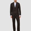 A man wears a Motion Blazer Regular Cognac over a white collared shirt and black dress shoes, reflecting a clean Scandinavian design.