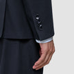 A dark blue sleeve of the Motion Blazer Regular Midnight Blue with four buttons at the cuff and a glimpse of a light-colored striped shirt sleeve underneath.