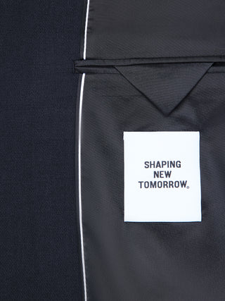 Inside a Motion Blazer Regular Midnight Blue, a tailored dark blue blazer, with a white fabric tag reading SHAPING NEW TOMORROW.