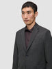 A man wearing a lightweight, breathable Motion Blazer Regular Pepper Grey over a dark button-down shirt.