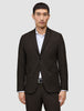 A man wears a Motion Blazer Slim Cognac, a tailored, dark brown two-button blazer in lightweight, breathable fabric over a white dress shirt.