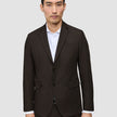 A man wearing a dark brown Motion Blazer Slim Cognac tailored over a white collared shirt.
