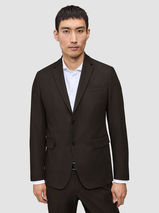 A man wearing a dark brown Motion Blazer Slim Cognac tailored over a white collared shirt.