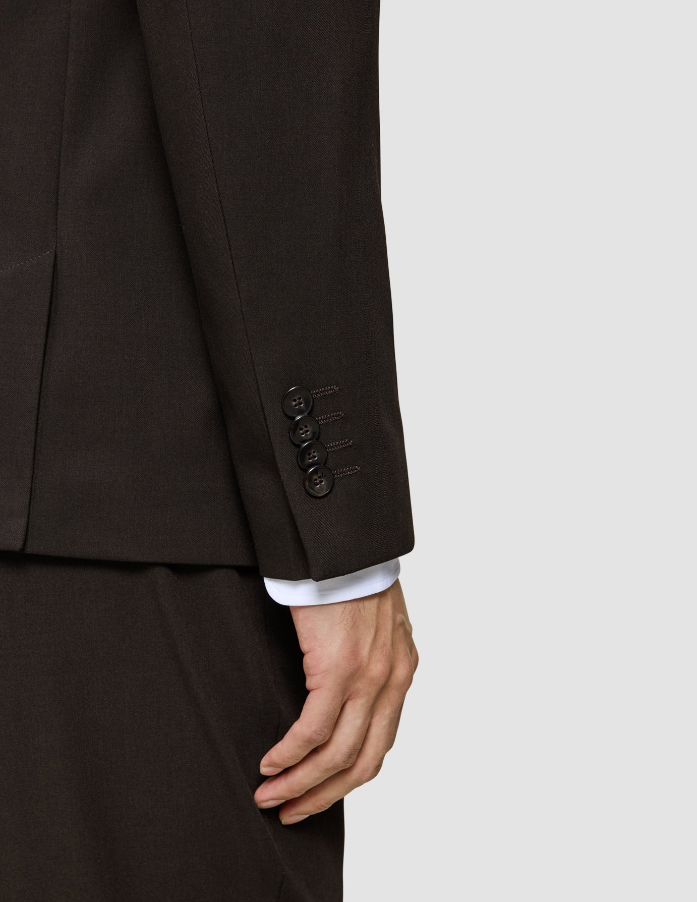 Close-up of the Motion Blazer Slim Cognac sleeve in lightweight, breathable fabric, featuring four buttons at the cuff and a white shirt cuff visible underneath.