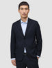 A man wearing a Motion Blazer Slim Midnight Blue over a light blue striped dress shirt.