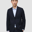 A man wearing a Motion Blazer Slim Midnight Blue over a light blue striped dress shirt.
