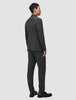 A man seen from behind wearing a Motion Blazer Slim Pepper Grey and matching trousers with dark loafers.