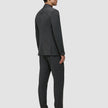 A man seen from behind wearing a Motion Blazer Slim Pepper Grey and matching trousers with dark loafers.