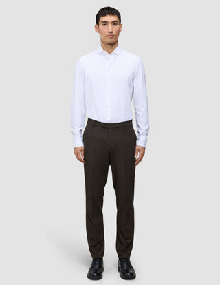 A man wearing a white button-down shirt, Motion Suit Pants Regular Cognac, and black dress shoes.