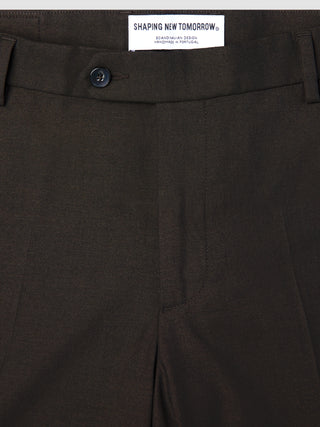 Close-up of Motion Suit Pants Regular Cognac, featuring lightweight, breathable brown fabric with a center button closure and a brand label at the waistband.