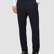 A man wearing a white dress shirt, Motion Suit Pants Regular Midnight Blue, and dark brown loafers.