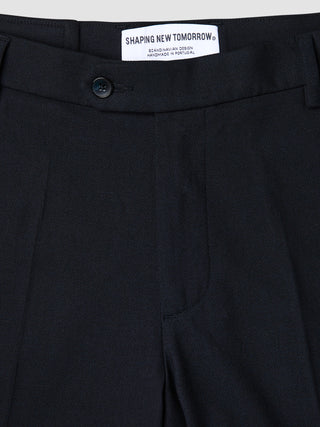 Close-up of the waistband and top of Motion Suit Pants Regular Midnight Blue, featuring a button closure and internal brand label on 360° stretch dark blue fabric.