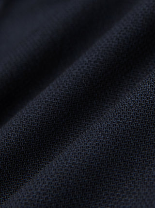 Close-up of Motion Suit Pants Regular Midnight Blue featuring lightweight, dark blue fabric with a visible, breathable woven texture and subtle folds.