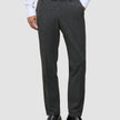 A man wearing Motion Suit Pants Regular Pepper Grey, a white button-down shirt, and black loafers.