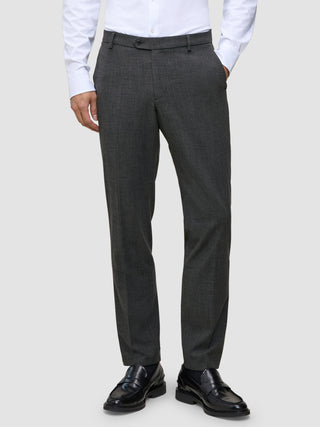 A man wearing Motion Suit Pants Regular Pepper Grey, a white button-down shirt, and black loafers.