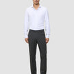 A man wearing a white button-down shirt, Motion Suit Pants Regular Pepper Grey, and black dress shoes.