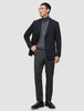 A man wearing a black blazer, grey turtleneck, and Motion Suit Pants Regular Pepper Grey.