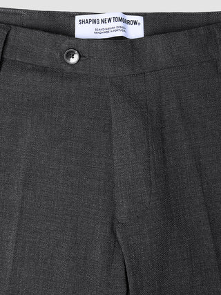 Close-up of Motion Suit Pants Regular Pepper Grey in charcoal grey 360° stretch fabric, featuring a button closure and a brand label at the waistband.